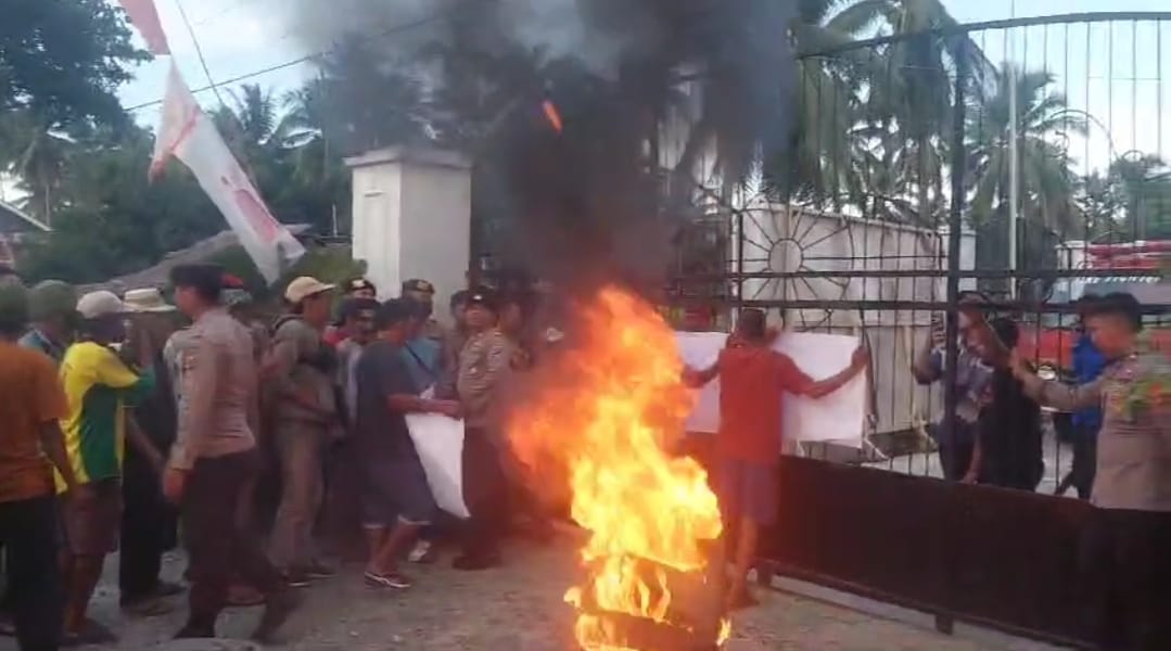 Massa Aksi bakar ban bekas di depan Kantor KPU Touna, pada Jumat (13/12/2024 sore