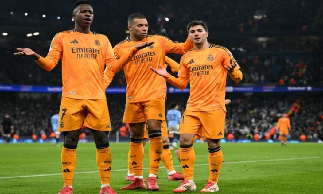 Vinicius Junior (kiri) dan Kylian Mbappe ikut merayakan gol Brahim Diaz untuk Real Madrid ke gawang Man City pada duel Liga Champions di Stadion Etihad (11/2/2025). (OLI SCARFF/AFP)