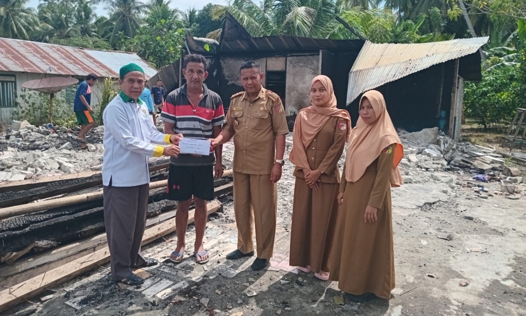 Ketua Baznas di dampingi Kepala BPBD Tojo Una-Una saat menyerahkan Bantuan pada warga yang mengalami musibah kebakaran Rumah (Foto Baznas Touna)