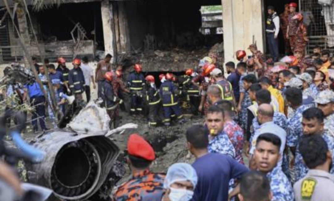 Petugas pemadam kebakaran mencari korban selamat setelah jet tempur AU Bangladesh jatuh di sebuah kampus tak lama setelah lepas landas di Dhaka, Bangladesh, Senin (21/7/2025). (Foto: AP)