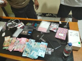 Polisi Sita barang bukti dua paket yang berisikan serbuk kristal diduga narkotika jenis sabu seberat 0,25 gram, 2 buah timbangan digital, 1 alat hisab bong, 10 korek api gas, 1 Hp Oppo, 4 pack plastick bening, 2 buah gunting, 1 kaca pirex serta uang sebesar Rp 1.775.000