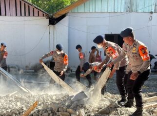 Tim SAR Kompi 4 Batalyon A Pelopor Satbrimob Polda Sulawesi Tengah bergotong royong membersihkan puing-puing bangunan yang roboh akibat gempa bumi di Kabupaten Buol, Jumat (17/7/2026).
