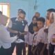 (Foto: Rahmawati Tane), Wakil Bupati Tojo Una-Una Surya didampingi jajaran Dinas Pendidikan dan Kebudayaan menyerahkan bantuan seragam sekolah kepada peserta didik baru jenjang TK, SD, dan SMP di Kecamatan Tojo Barat, Selasa (14/7/2026).