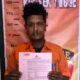 Tersangka berinisial RF (28) mengenakan pakaian tahanan berwarna oranye saat menunjukkan surat penetapan tersangka dan penahanan dari pihak kepolisian.