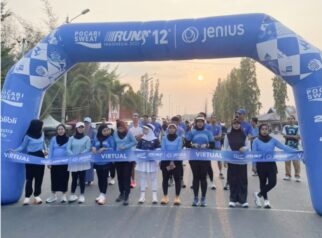 Para peserta berfoto bersama di garis start jelang dimulainya Pocari Sweat Run Indonesia 12th 2025 di kawasan Taman JH Ampana, Kabupaten Tojo Una-Una. Kegiatan berlangsung semangat di pagi hari dengan keindahan matahari terbit sebagai latar.