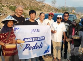 Pengurus JMSI Sulawesi Tengah berfoto bersama para pekerja saat penyaluran bantuan makanan dalam kegiatan sosial "Jumat Berbagi" di kawasan TPA Kawatuna, Kota Palu, Jumat (2/10/2026).