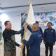 Ketua PD JMSI Sulawesi Tengah, Murtalib, menyerahkan bendera pataka kepada Ketua PC JMSI Kabupaten Tojo Una-Una dalam acara pelantikan kepengurusan periode 2026–2031 di Gedung Serba Guna Dinas Pariwisata Tojo Una-Una, Sabtu (31/10/2026).