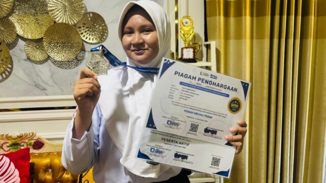 Qisya Zahra Alimun menampilkan medali dan piagam penghargaan yang diraih dalam Festival Sains Digital Nasional (FSDN) 2026, Oktober 2026. Qisya berhasil meraih medali emas bidang IPA dan medali perak bidang Biologi.